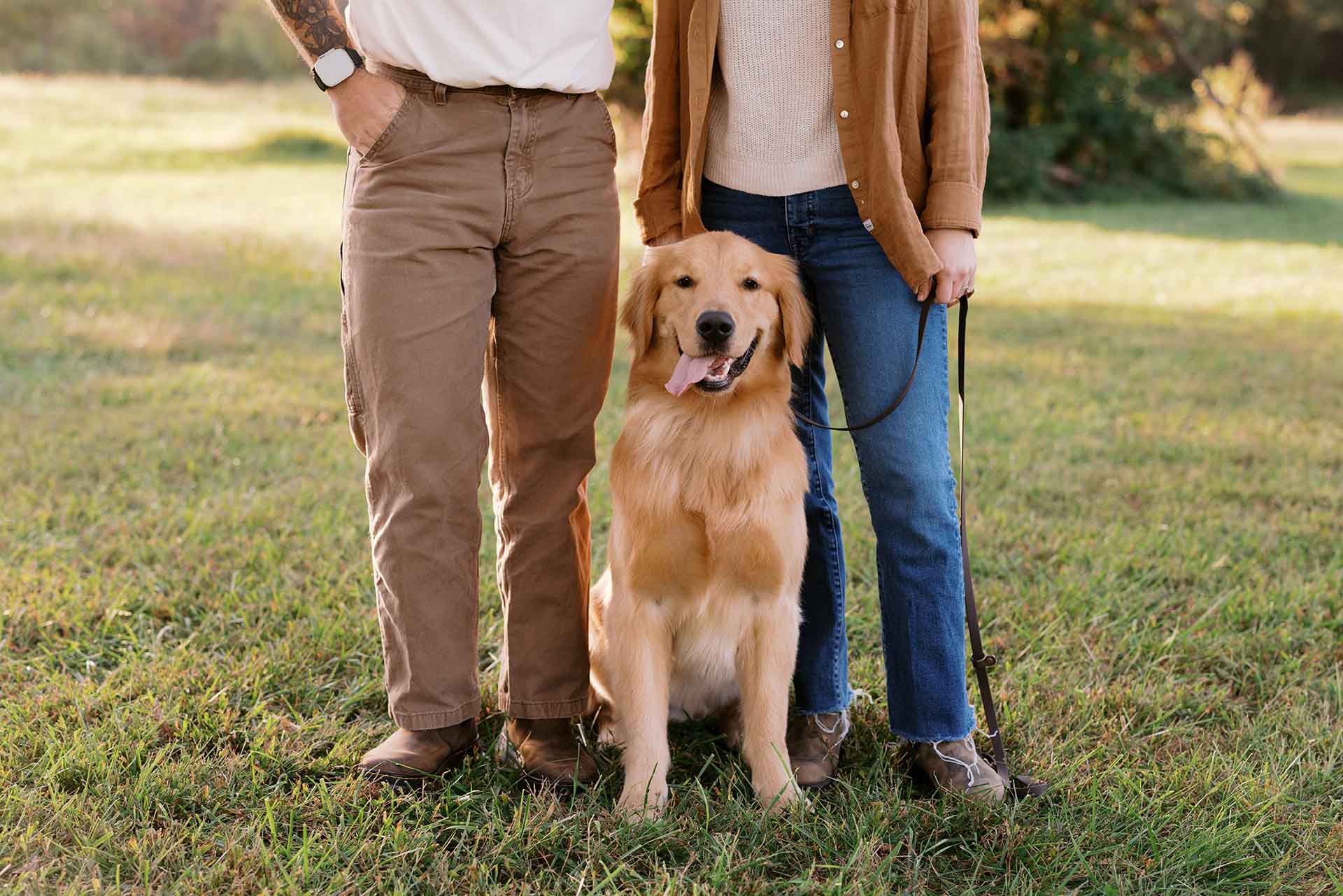Couple standing with Golden Retriever
